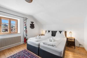 a bedroom with a large bed with white sheets and a window at Alter Brotladen - Melk Center in Melk