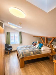 a bedroom with a bed and a chair in it at Hotel Garni Villa Areka in Český Krumlov