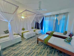 a bedroom with two beds and drapes at Karibu House Paje in Paje