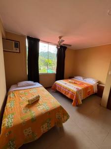 two beds in a room with a window at Cerro Verde in San Ramón +12 photos