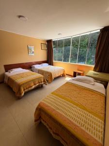 a hotel room with two beds and a window at Cerro Verde in San Ramón