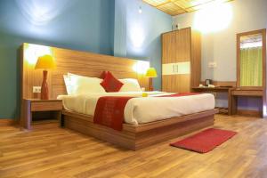 a bedroom with a large bed and a desk at pristine mountain lodge in Chail +6 photos