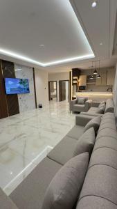 a living room with couches and a flat screen tv at شاليهات الحدبان - Al Hadban Chalets in Ash Shafa