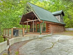a cabin in the woods with a large porch at Serenity in Townsend