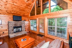 a living room with a fireplace in a log cabin at Serenity in Townsend