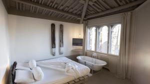 a bedroom with a bed and a tub and a sink at B&B A Piazza del Gesù in Viterbo