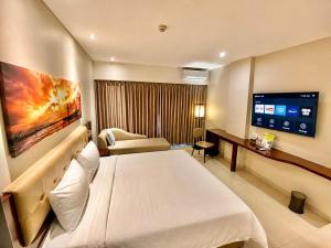 a hotel room with a bed and a flat screen tv at PrimeBiz Tegal in Tegal