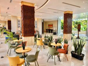 a restaurant with tables and chairs in a lobby at PrimeBiz Tegal in Tegal