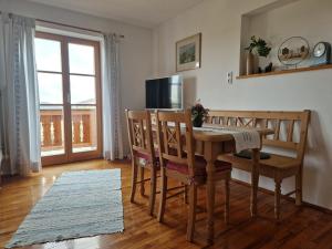 ein Esszimmer mit Tisch und Stühlen und einem Fenster in der Unterkunft Agelbauer in Irschenberg