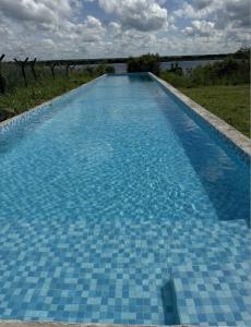 a blue tile swimming pool with a view of the ocean at Big 5 Toro Lodge in Kasane