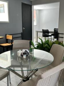 a glass table and chairs in a room at Hotel Palmas del Estadio in Medellín +40 photos