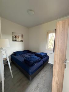 a bedroom with a blue bed in a room at Lakeside Retreat at Veluwe in Nunspeet +21 photos