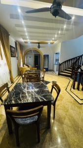 a dining room with a table and chairs and a staircase at Seaview lodge Executive in Karachi