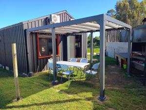 a table and chairs under a canopy in a yard at Pinot Noir in Piriápolis