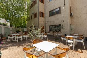 an outdoor patio with tables and chairs and a building at Hotel Vila e Arte City Center in Tirana