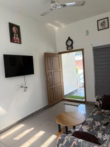 a living room with a couch and a table and a tv at Whitefort Family Villa Alleppy-Homestay in Alleppey
