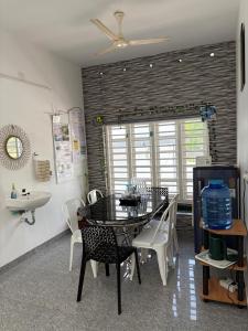 a dining room with a table and chairs and a sink at Whitefort Family Villa Alleppy-Homestay in Alleppey