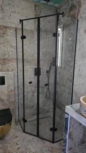 a shower with a glass door in a bathroom at Szirom apartman in Szeged