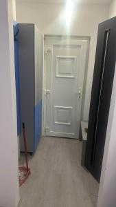 a room with a white door and a red shovel at Szirom apartman in Szeged
