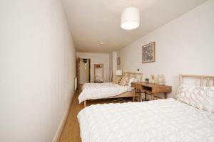 a bedroom with two beds and a desk in it at The MCR Prime Pad in Manchester