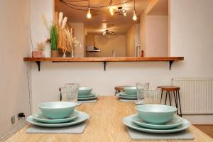 a table with bowls and plates on top of it at The MCR Prime Pad in Manchester +7 photos