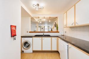 a kitchen with a sink and a washing machine at The MCR Prime Pad in Manchester