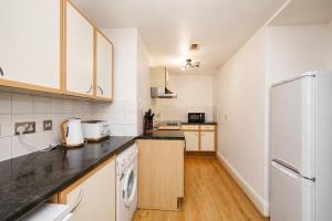a kitchen with white appliances and a white refrigerator at The MCR Prime Pad in Manchester
