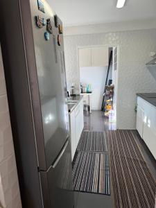 a kitchen with a stainless steel refrigerator at The room in Odivelas