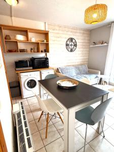a kitchen with a table and chairs in a room at Studio cosy les Sables d'Or in La Guérinière