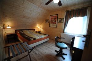 a bedroom with a bed and a chair in a room at Willa pod stokiem Bolesławów in Bolesławów