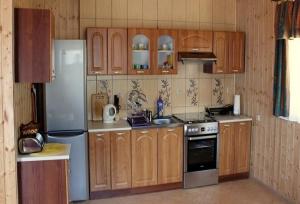 a kitchen with wooden cabinets and a refrigerator at Willa pod stokiem Bolesławów in Bolesławów