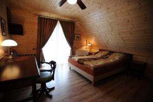 a bedroom with a bed and a desk and a window at Willa pod stokiem Bolesławów in Bolesławów