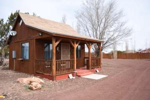 a small wooden cabin with a porch on a dirt road at Dumplin Patch Bed & Breakfast in Williams