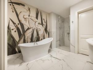 a bathroom with a bath tub and a bird mural at Hotel Traugutta 12 in Łódź +78 photos