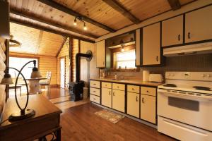 a kitchen with white appliances and a wooden ceiling at Chalet Le RV 3 in Notre-Dame-Des-Bois