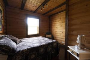a bedroom with a bed in a wooden room at Chalet Le RV 3 in Notre-Dame-Des-Bois