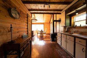 a kitchen with wooden walls and a clock on the wall at Chalet Le RV 3 in Notre-Dame-Des-Bois