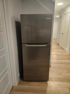 a stainless steel refrigerator in a room with a hallway at Serene Luxury Suite in Riverview