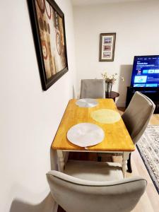 a dining room table with chairs and a television at Serene Luxury Suite in Riverview +2 photos