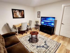 a living room with a couch and a table and a television at Serene Luxury Suite in Riverview