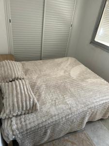 a bed with a blanket on it in a bedroom at Appartement du bonheur in Nabeul
