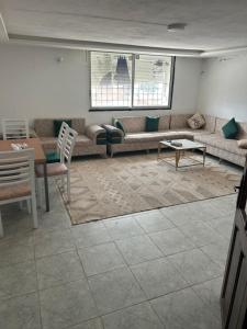 a living room with a couch and a table at Appartement du bonheur in Nabeul