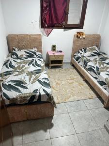 a bedroom with two beds and a rug at Appartement du bonheur in Nabeul
