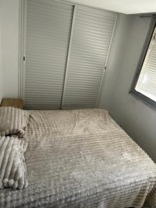 a white bed in a bedroom with a window at Appartement du bonheur in Nabeul