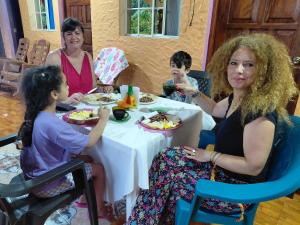 a group of people sitting around a table eating food at Casa Caimana in Moyogalpa