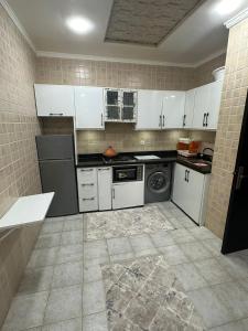 a kitchen with white cabinets and a washer and dryer at corniche d or piscine ferme le lundi in Mohammedia