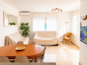 a living room with a wooden table and chairs at Casa Marga - " Pet friendly - Piscina Privada - Playa - BBQ - Parking - Delta de l'Ebre - Riumar" in Riumar