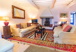 a living room with white couches and a rug at Castello di Fighine in San Casciano dei Bagni