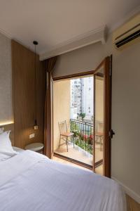a hotel room with a bed and a balcony at Hotel Vila e Arte City Center in Tirana +73 photos