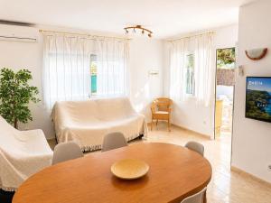 a living room with a table and a couch at Casa Sastre - "Pet Friendly - Piscina Privada - Playa - BBQ - Parking - Delta de l'Ebre - Riumar" in Riumar